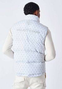 Gilet imbottito bianco con un sottile motivo a logo ripetuto, dotato di un alto colletto e testo ricamato "PROJECT X PARIS" sulla schiena.