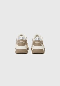 Sneaker beige con accenti argentati, materiale testurizzato, forma rotonda, collare imbottito e suola in gomma a contrasto.