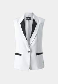 Biely bezrukávový blazer s čiernym šálovým golierom, dvoma prednými vreckami s čiernymi akcentmi a jedným gombíkom na zapínanie.