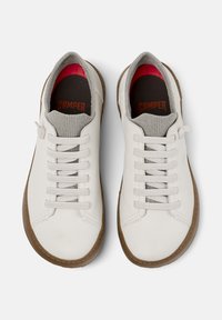 White leather sneakers with gray knitted collar and beige rubber sole, featuring flat laces and red inner lining. Brand text visible on insoles.