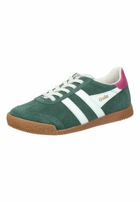 Zapatillas de ante verde con rayas blancas, acento rosa en el talón, suela de goma texturizada y cordones blancos. Logo de la marca en el costado.