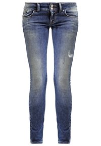 Jean slim bleu avec cuisses délavées, légère usure sur la jambe droite, fermeture double bouton et design à cinq poches.