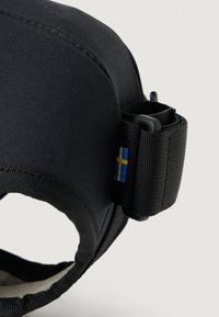 Svart tekstilrem med en buet profil og justerbar spenne. Har et lite svensk flagg-emblemet og en glatt indre tekstur.