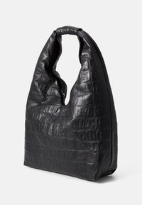 Bolso de imitación de cuero negro con un patrón de cocodrilo texturizado, forma única y un asa redondeada. Presenta una base triangular.