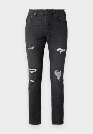 Mustad džinsi slim fit stiilis, millel on mitmed kulumise kohad ja nähtavad paigatud detailid põlvedel. Klassikaline viie taskuga disain.