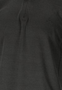 Schwarzer Half-Zip-Pullover aus strukturiertem Stoff. Mit dezenten Logo- und Steppdetails. Leichtes Design, ideal zum Layering.