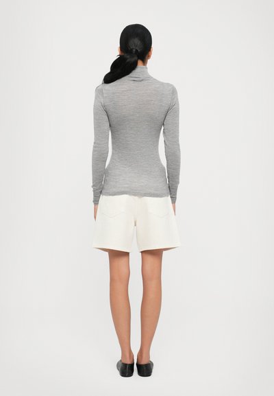 Gray long-sleeve turtleneck top paired with white shorts. The top has a fitted design, while the shorts feature front pockets and a relaxed fit.