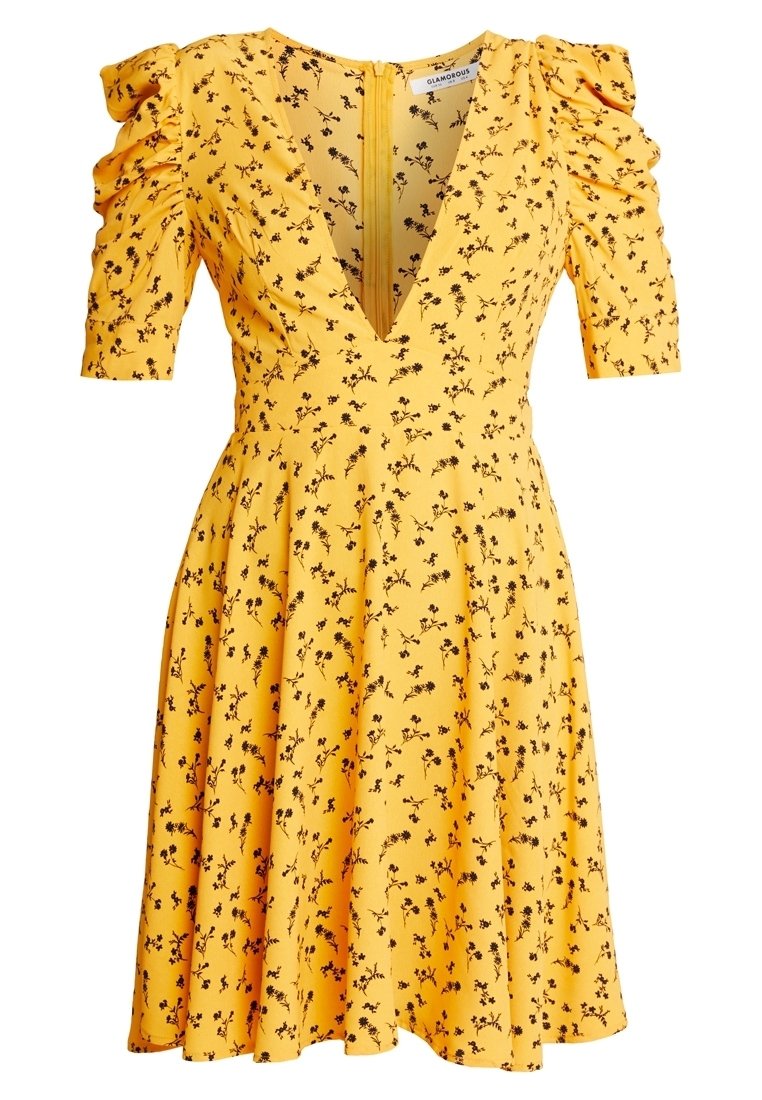 Robe courte jaune avec un petit imprimé floral noir, décolleté profond en V, manches bouffantes froncées et jupe évasée.