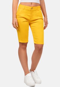 Gele katoenen shorts met een slim fit en een knielange snit. Bevat voorzakken, riemlussen en een zilveren knoopdetail bij de tailleband.