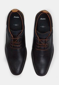 Black leather dress shoes with a perforated texture, contrasting brown laces, and a smooth toe cap. Inside features “Bata” and "Italian Design" branding.