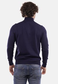 Maglione pullover blu navy con collo alto, maniche lunghe e polsini a costine, realizzato in morbido tessuto a maglia. Visto da dietro.