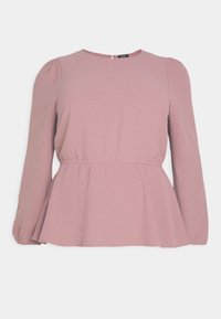 Haut à manches longues rose avec un col rond, détails froncés aux épaules et basque. Texture de tissu lisse, subtil éclat.