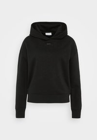 Felpa nera con cappuccio realizzata in tessuto morbido. Ha un design cropped, polsini a coste e un piccolo logo etichetta sul petto.