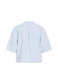 Chemise bleu clair à manches courtes avec un pli dans le dos et un petit logo brodé près de l’ourlet inférieur sur fond blanc.