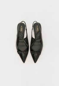 Črne slingback petke s koničastim nosom, izdelane iz gladke usnje, ki vsebuje detajl pentlje na zgornjem delu. Minimalističen dizajn z eleganjem zaključkom.
