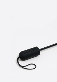 Must musta käepide, millel on reljeefne "BIMBA" tekst, kinnitatud õhukesele mustale nöörile. Sile tekstuur, ovaalne kuju, minimalistlik disain.