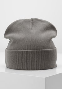 Sivi pleteni beanie s rubom, koji ima rebrastu teksturu i opušteni vrh. Glatka tkanina, fleksibilna prilagodba i minimalistički dizajn.