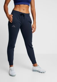 Námořnické joggingové kalhoty s elastickým pasem, šňůrkou a bočními kapsami. Na levém stehně je bílá ploška s logem Kappa. Návleky na kotnících.