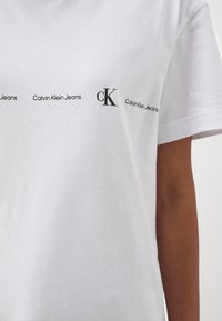 Calvin Klein Jeans LOGO REPEAT - Camiseta estampada - bright white