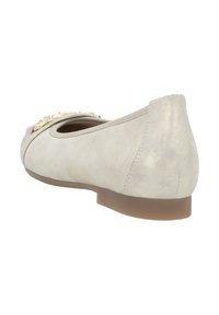 Beige Wildleder Ballerina mit abgerundetem Zehenbereich, goldfarbener Kettenakzent und niedrigem Absatz. Glatte Textur, minimale Nähte und leichter Glanz.