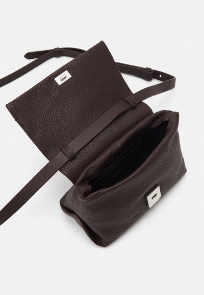Καφέ δερμάτινη τσάντα ώμου με υφή, κούμπωμα από ασημένιο υλικό και μια ρυθμιζόμενη λουρί, με ανοιχτό εσωτερικό.