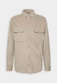 Beige fløjls-skjorte med lange ærmer, knaplukning foran, to brystlommer og krave. Lodret ribbet tekstur og plastikknapper.