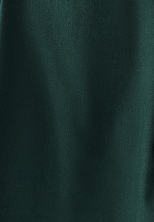 Zaļa auduma virsma ar gludu tekstūru un smalku spīdumu. Materiāls izskatās elpojošs un viegls, piemērots apģērbiem vai aksesuāriem.