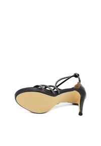 Scarpa con tacco alto nera con tomaia in pelle liscia, cinturini decorativi e suola texturizzata. Presenta una silhouette elegante e una punta appuntita.