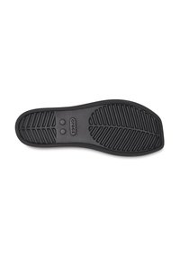 Black rubber shoe sole with textured tread pattern, featuring logo in the middle, designed for grip and durability. Smooth edges and rounded shape.