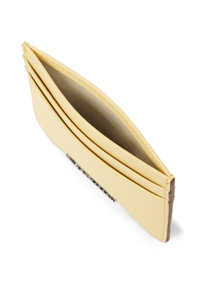 Porte-cartes fin en cuir jaune pâle avec trois emplacements pour cartes et un compartiment central ouvert, sur fond blanc.