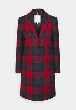 Manteau long tailleur pour femme avec grand motif à carreaux rouges et bleu foncé, revers à dents de chien, deux boutons et poches à rabat.