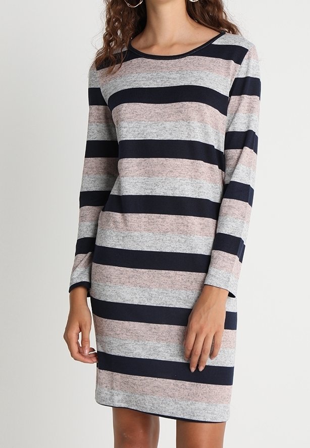 Femme portant une robe à manches longues, longueur genou, avec de larges rayures horizontales bleu marine, gris et rose clair.