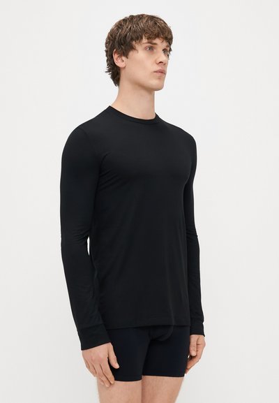 Ilga rankovė juoda marškinėliai, pagaminti iš švelnios medžiagos, su apvalia iškirpte. Tinkamo silueto, lygia tekstūra ir be matomų raštų ar akcentų.