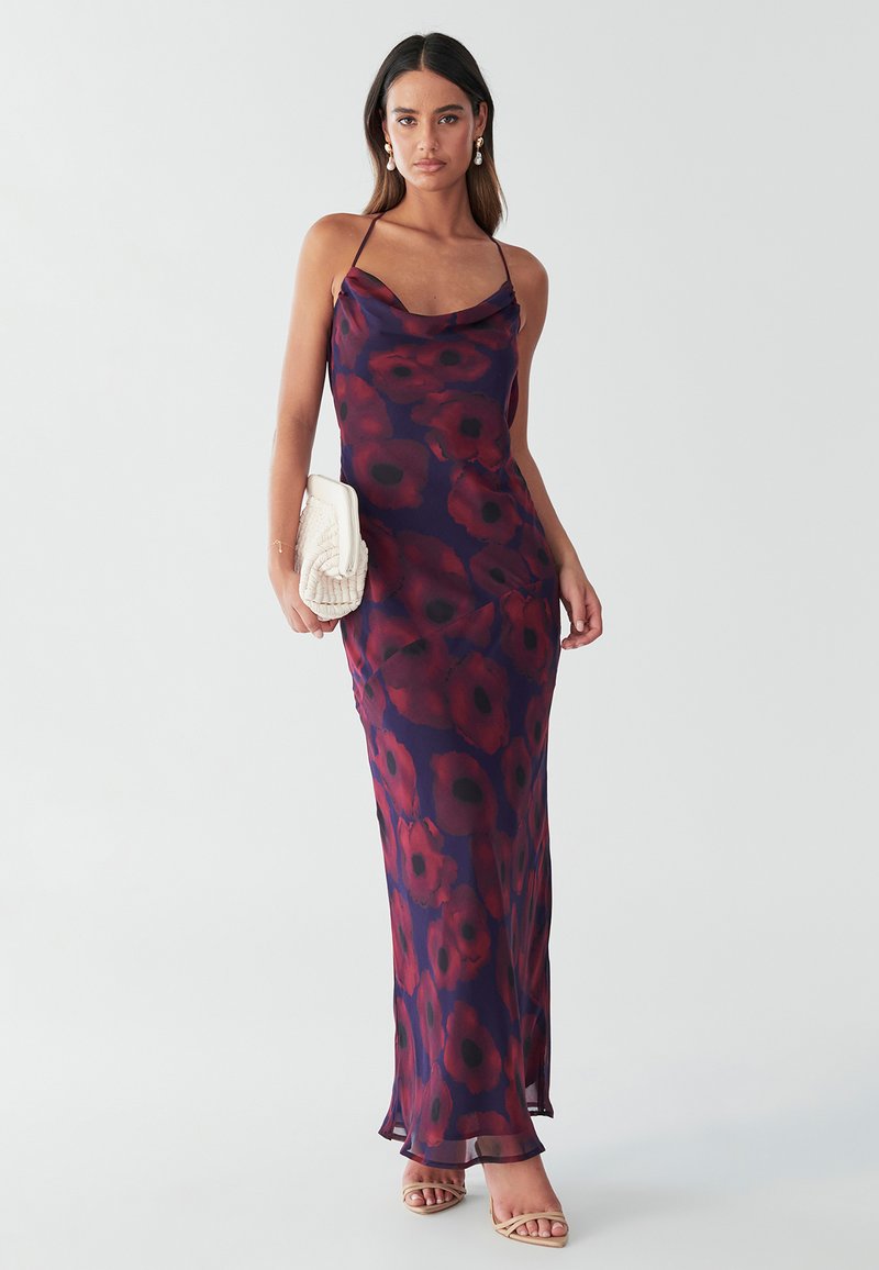 Saténové večerní šaty s temně fialovým základem a velkými červenými květinovými vzory; tenká ramínka; dlouhé po zem s volně splývajícím výstřihem.