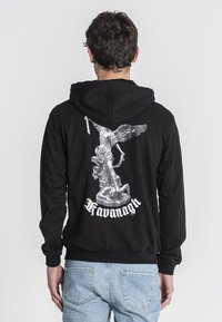Sudadera con capucha negra que presenta un gráfico plateado detallado en la parte posterior de una estatua alada y el texto "Kavanagh" en blanco debajo.