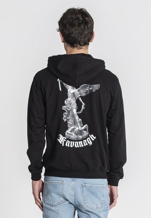 Zwarte hoodie met een gedetailleerde zilveren afbeelding op de achterkant van een gevleugeld standbeeld en de tekst "Kavanagh" in het wit eronder.
