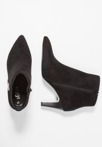 Black suede ankle boots with a pointed toe, zip closure on the side, and a slender high heel. Smooth texture and minimalist design.