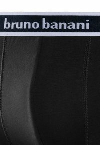 Svarta underkläder med ett brett elastiskt midjeband med "bruno banani"-logotyp i vitt. Slätt tyg och figurnära design med platta sömmar.