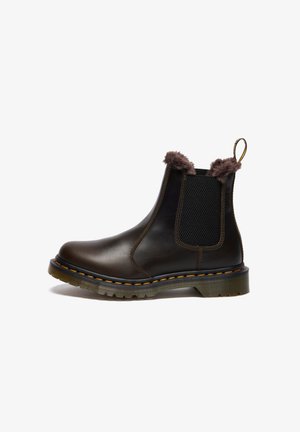Stivale Chelsea in pelle marrone con pannelli laterali elastici, bordi in finta pelliccia, cuciture gialle e suola in gomma rigata.
