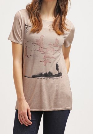 Beżowy T-shirt z krótkim rękawem z grafiką latających ptaków i sylwetką. Miękki materiał o luźnym kroju i zaokrąglonym dołem.