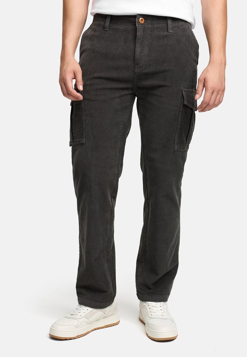 Sorte corduroy cargobukser med to sidelommer, en frontlukning med knap og en afslappet pasform, parret med hvide sneakers.