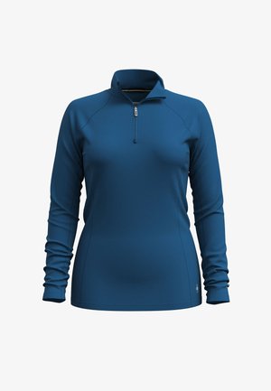Long-sleeve, zip-neck pullover in deep blue, made of smooth material. Features a fitted design with subtle stitching details and roll-up sleeves.