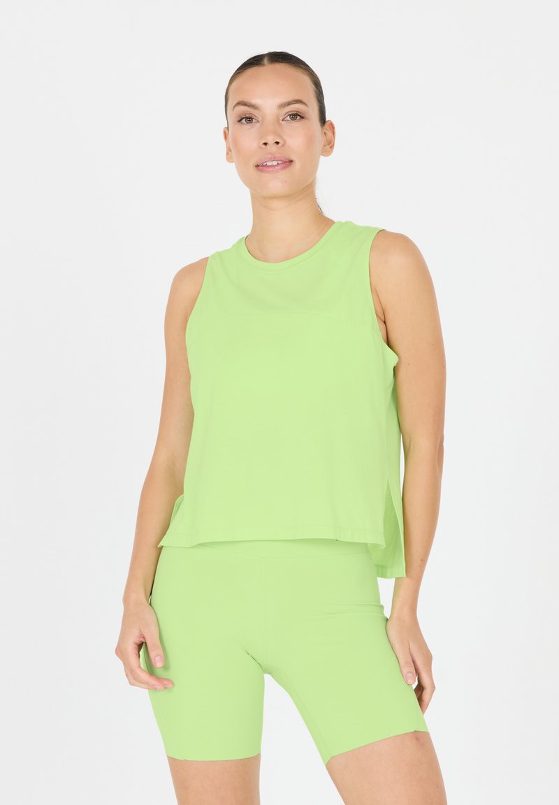Ljusgrön ärmlös topp med rundad halsringning, ihop med matchande cykelshorts. Mjukt tyg och avslappnad passform, minimal detaljering.