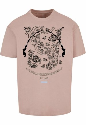 Lichtroze katoenen t-shirt met zwarte bloemen- en gezichtillustraties, met "M. Gonzales Design Department EST. 2015" in een cirkelpatroon.