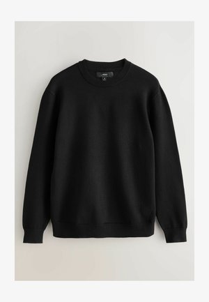 Črna majica s crew neck ovratnikom, ribastimi manšetami in obrobami. Narejena iz mehkega materiala, z značilno silhueto. Oznaka vidna na ovratniku.