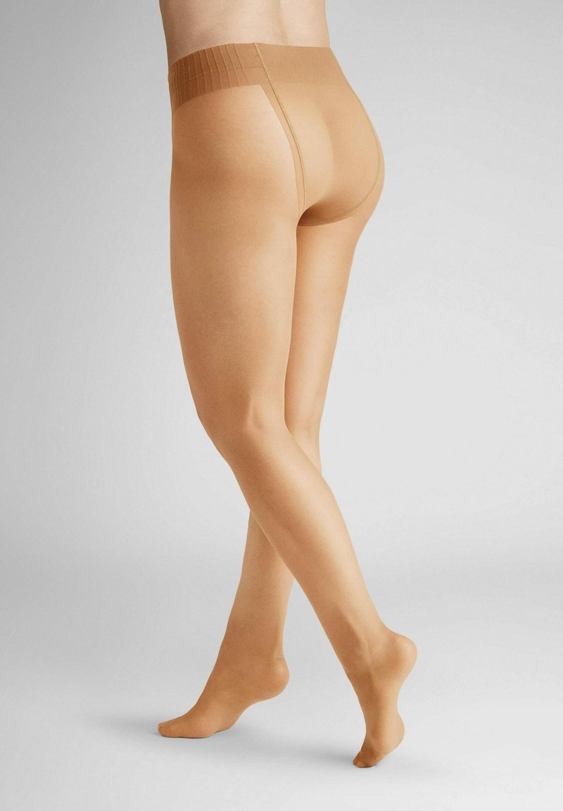 Beige sheer tights with a wide knitted waistband, smooth texture, and a lightweight design, showcasing legs from a turned perspective.