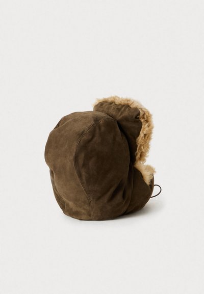 Sombrero de ante marrón con un suave forro de piel sintética, forma redondeada y detalle con cordón en la parte posterior. Superficie texturizada y acentos peludos.