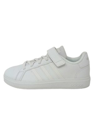 Baskets blanches en matériau synthétique, avec une texture lisse, des lacets, une sangle Velcro et trois rayures parallèles sur le côté.