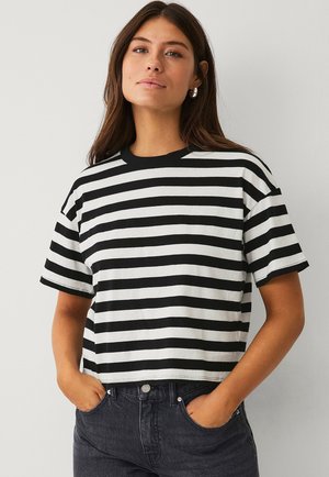 T-shirt court noir et blanc à rayures avec un col rond et des manches courtes, fabriqué à partir d'un tissu lisse. Présente une coupe décontractée.