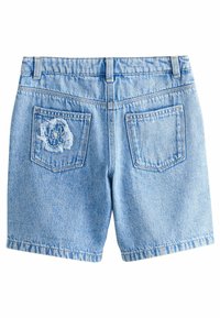 Shorts en denim bleu clair avec un patch fleuri effiloché sur la poche arrière, dotés de coutures standard et de deux poches arrière.